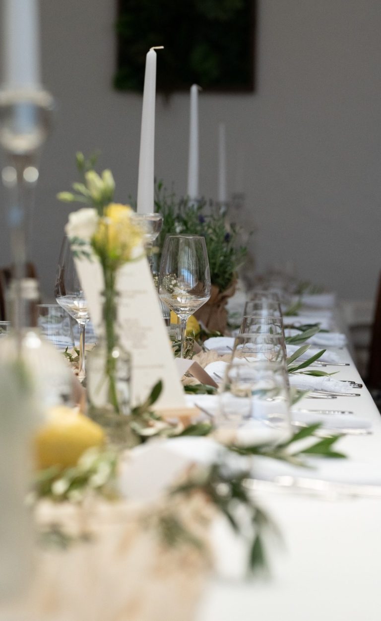 Festlich gedeckter Tisch mit Kerzen, Blumen und Dekoration für ein Event.